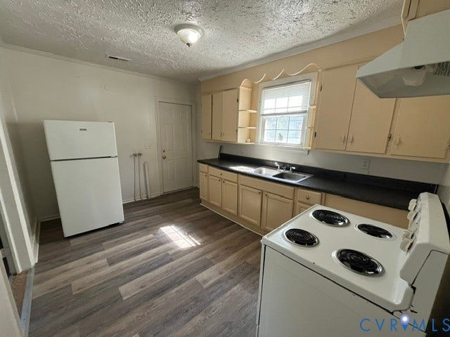 1227 Montgomery Avenue, Birdville Park, Petersburg, VA 23803 Kitchen featuring wood-finish flooring, ample cabinetry, dual-basin sink, and a window for natural light
