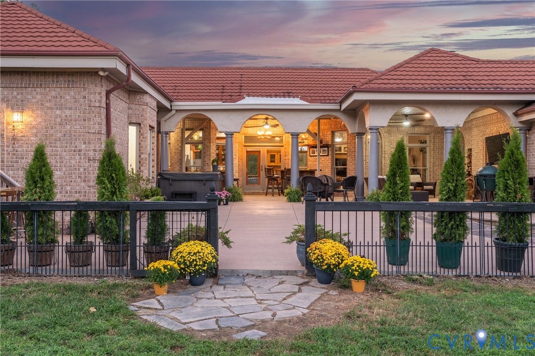The residence at twilight, with expansive outdoor living spaces overlooking the farm.