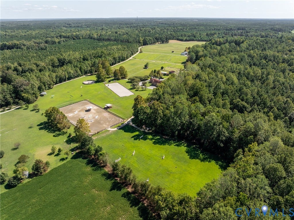 An aerial perspective showcases the scale, privacy and extensive equestrian infrastructure of the property.