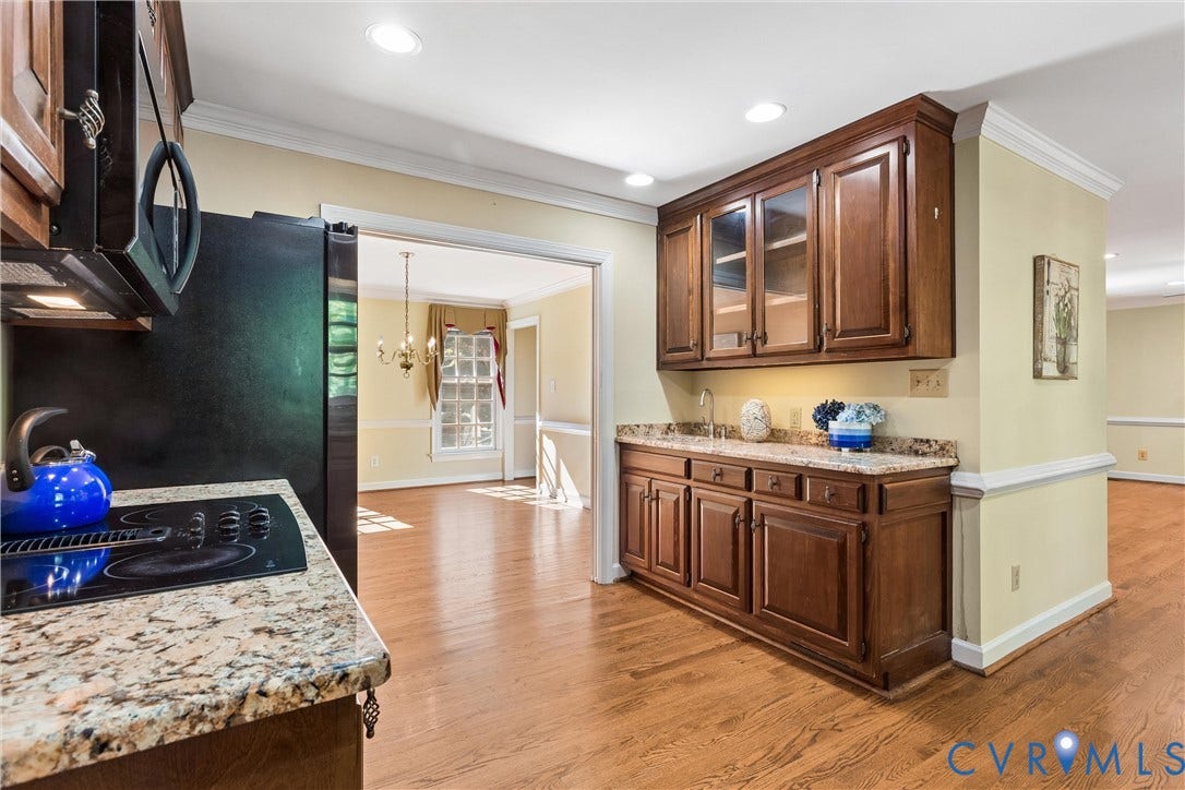 Kitchen featuring integrated cooktop, granite countertops, wood-finish flooring, built-in cabinetry, and recessed lighting