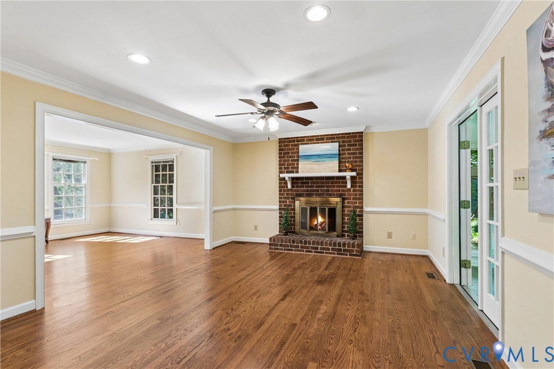 Hardwood flooring, brick fireplace with mantel, recessed lighting, ceiling fan, and French doors