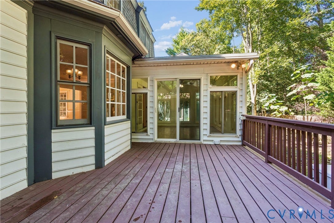 Expansive outdoor deck with wood-finish flooring and a wood railing