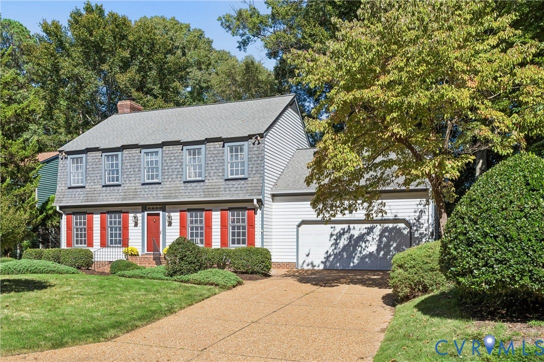 Traditional-style residence featuring a gambrel roof and red shutters