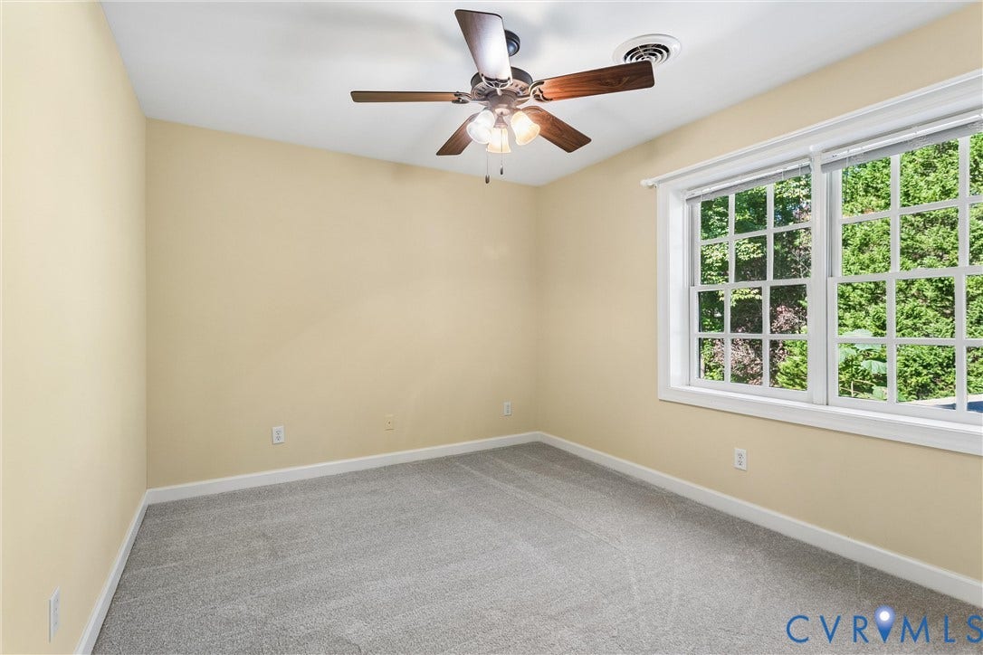 Carpeted room with a ceiling fan, recessed lighting, and a large window