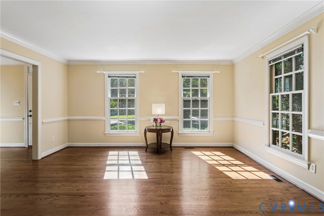 Hardwood flooring, multiple windows, crown molding, chair rail molding, and a cased opening