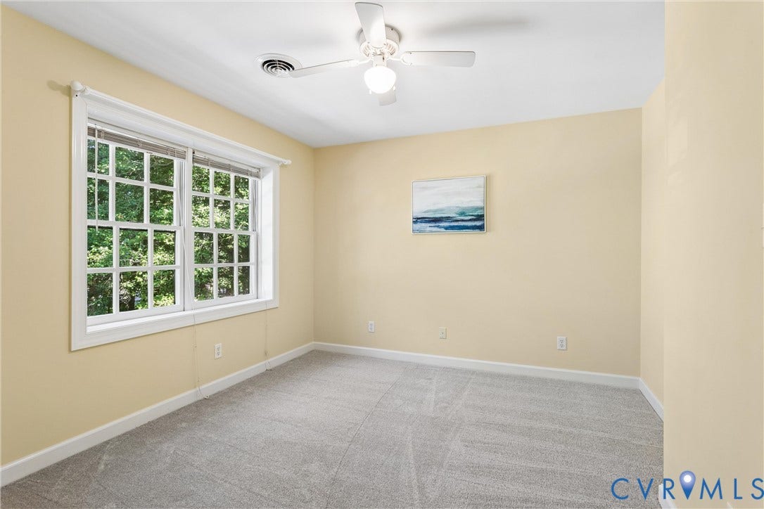 Wall-to-wall carpeting, overhead ceiling fan, and large double-hung windows