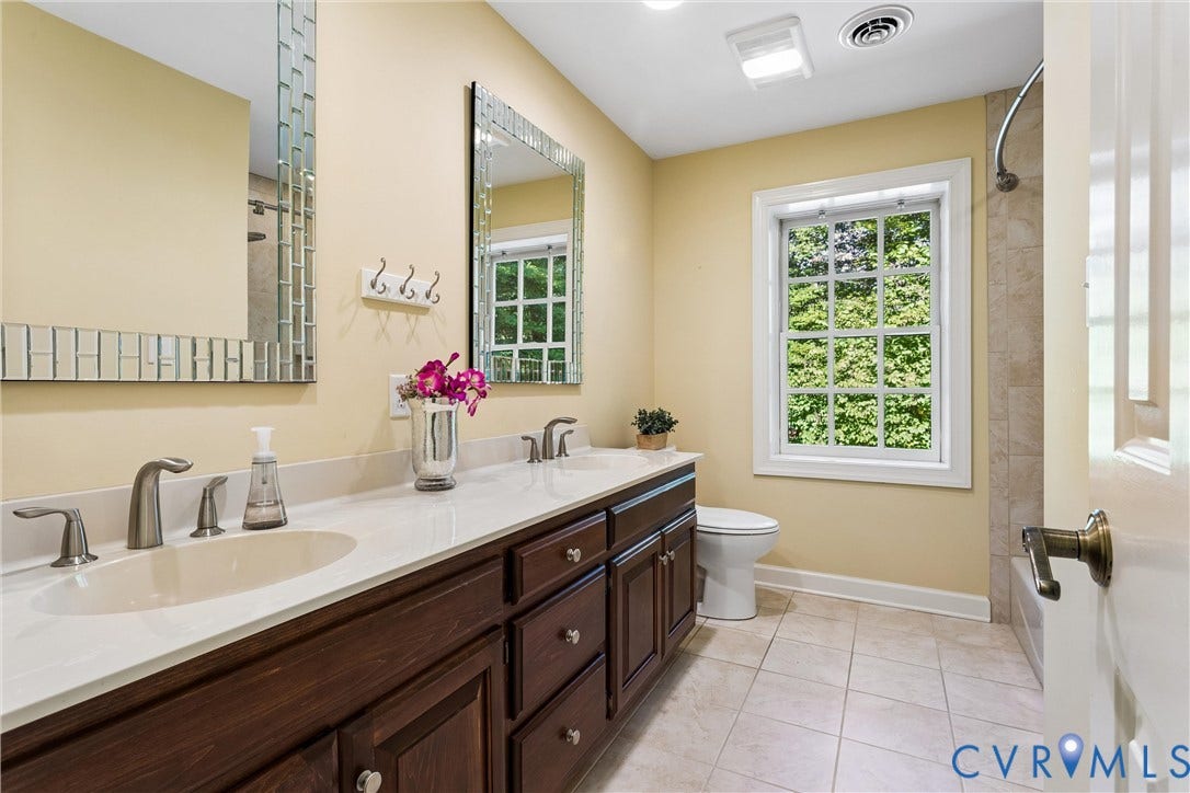 Dual vanity with white countertop, dark wood-finish cabinetry, and brushed nickel fixtures
