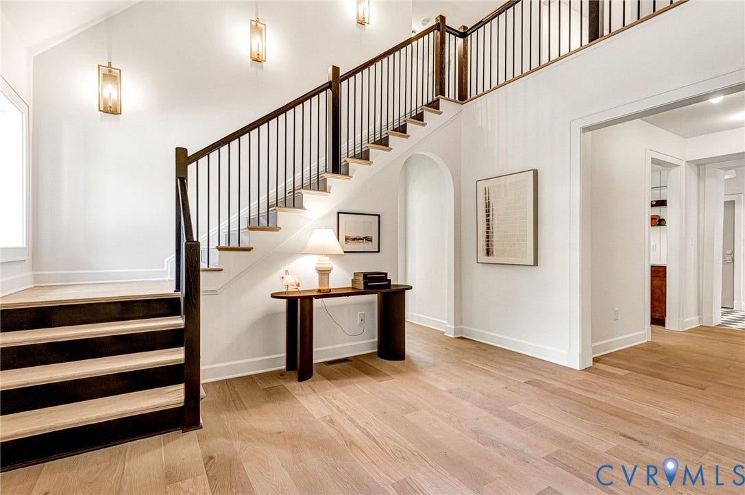 404 Waveny Road, Westham, Henrico, VA 23229 Entryway featuring wood-finish flooring, a staircase with custom dark wood railings and balusters, vaulted ceilings, and wall-mounted geometric lantern lighting