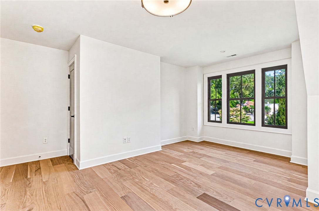 404 Waveny Road, Westham, Henrico, VA 23229 Interior room featuring wood-finish flooring, a triple-pane window configuration with dark frames, and a central ceiling-mounted flush light fixture
