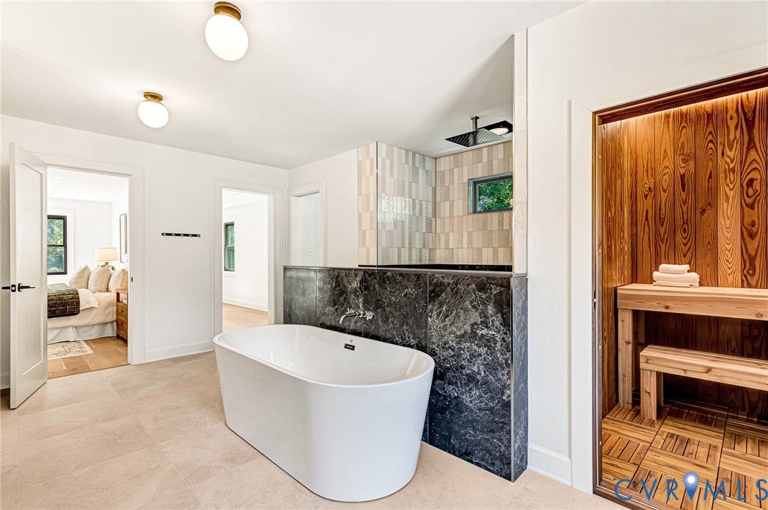 404 Waveny Road, Westham, Henrico, VA 23229 Freestanding white soaking tub with wall-mounted faucet, stone-surround shower area, and built-in sauna featuring wood paneling and bench seating