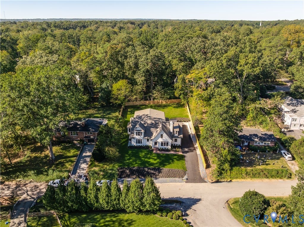 404 Waveny Road, Westham, Henrico, VA 23229 Aerial perspective of a detached residence featuring a multi-gabled roofline, light-colored siding, an asphalt driveway, and a fenced-in rear lawn surrounded by mature trees