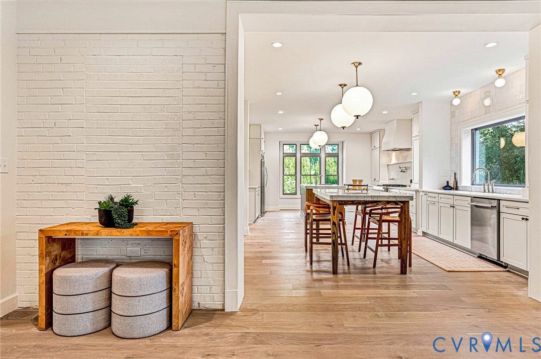 404 Waveny Road, Westham, Henrico, VA 23229 Painted white brick wall, wood-finish flooring, white cabinetry, integrated stainless steel appliances, and spherical pendant lighting
