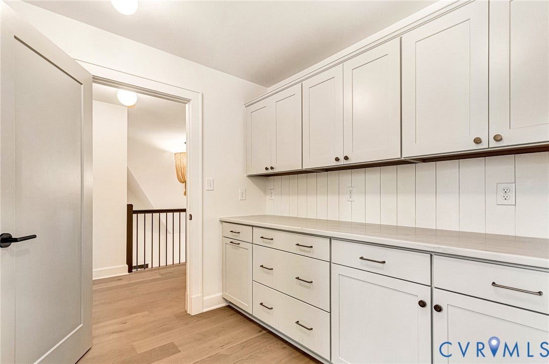 404 Waveny Road, Westham, Henrico, VA 23229 Custom cabinetry with Shaker-style doors, stone-finish countertops, vertical shiplap backsplash, and wood-finish flooring