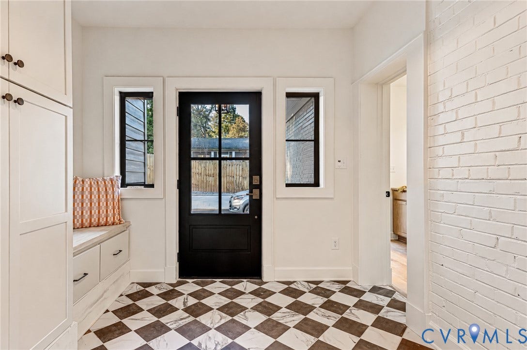 404 Waveny Road, Westham, Henrico, VA 23229 Entryway featuring a black-paned glass door, checkerboard tile flooring, built-in cabinetry with bench seating, and a painted white brick accent wall