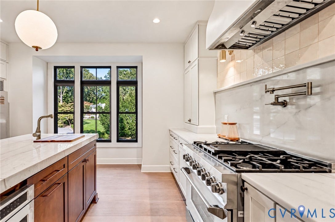 404 Waveny Road, Westham, Henrico, VA 23229 Kitchen featuring a professional-grade stainless steel range, white stone countertops, custom cabinetry with a wood-finish island, a wall-mounted pot filler, and oversized windows with black frames