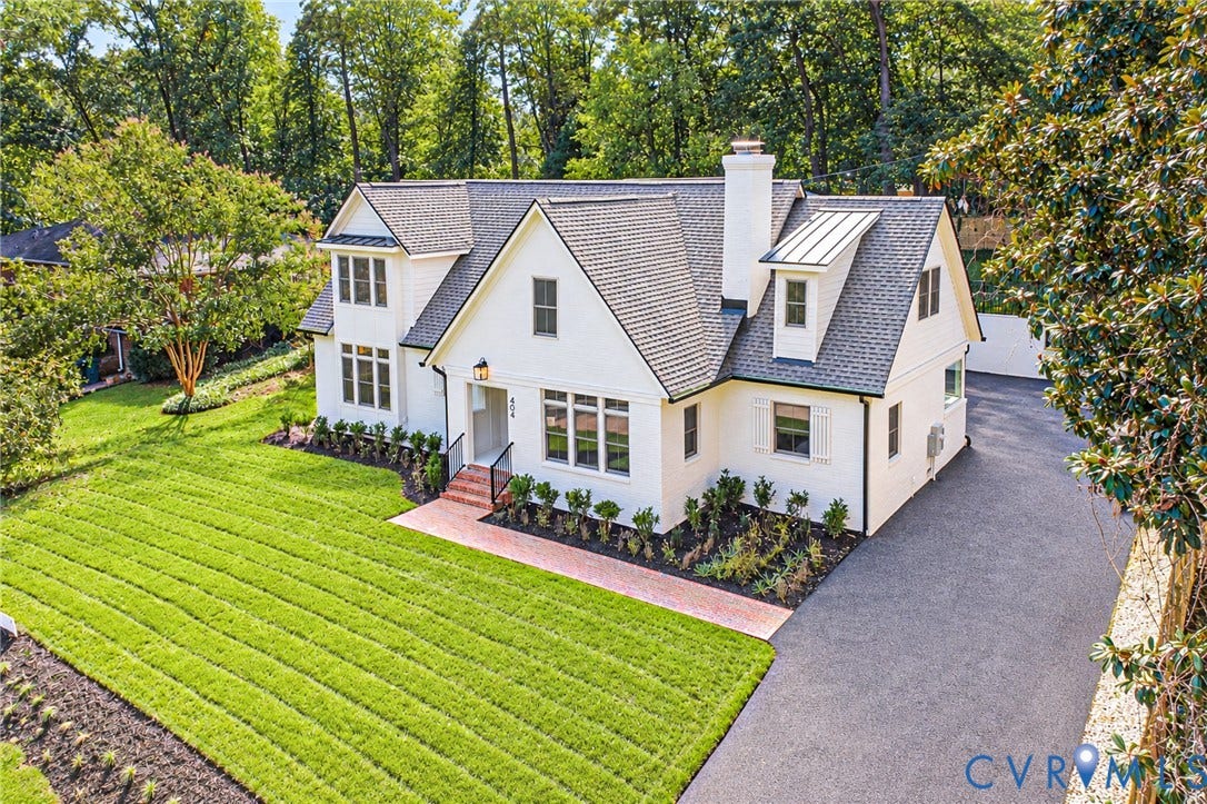 404 Waveny Road, Westham, Henrico, VA 23229 Multi-gabled exterior featuring white painted masonry, an asphalt shingle roof, a red brick walkway, and an expansive paved driveway