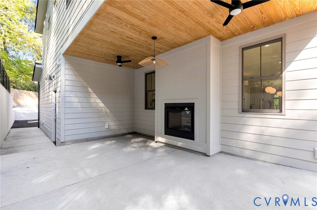 404 Waveny Road, Westham, Henrico, VA 23229 Covered patio featuring a concrete floor, wood-plank ceiling, built-in outdoor fireplace, ceiling-mounted fans, and modern horizontal siding