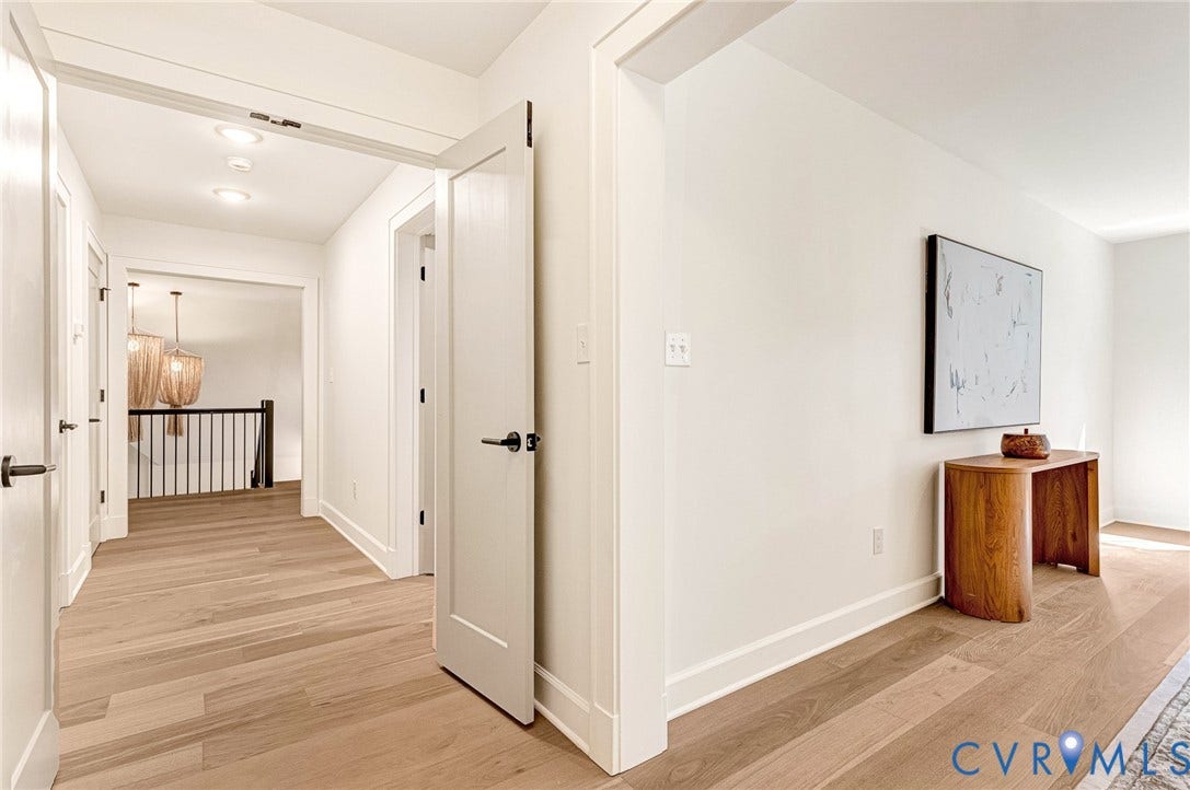 404 Waveny Road, Westham, Henrico, VA 23229 Hallway featuring light wood-finish flooring, shaker-style interior doors with matte black hardware, and crisp white trim