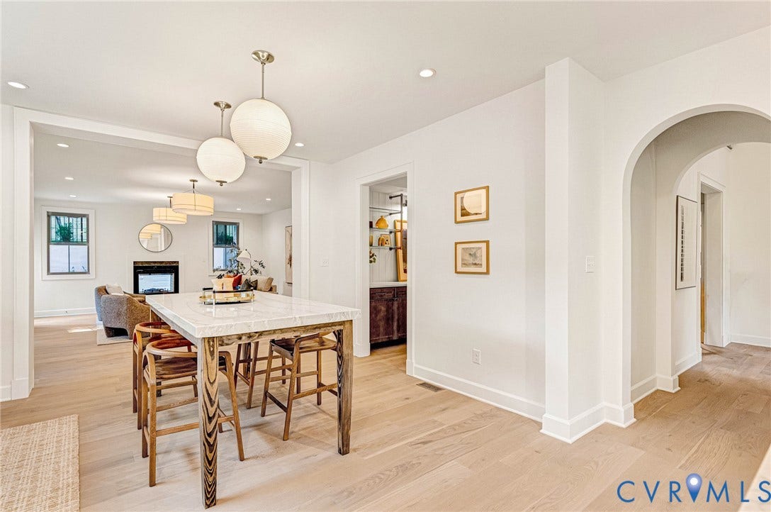 404 Waveny Road, Westham, Henrico, VA 23229 Open-concept interior featuring light wood-finish flooring, an arched entryway, recessed lighting, spherical pendant fixtures, and a stone-topped island