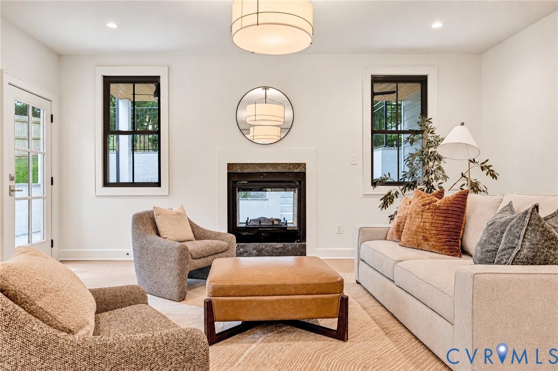 404 Waveny Road, Westham, Henrico, VA 23229 Fireplace with stone-style surround, double-hung windows with black frames, recessed ceiling lighting, drum-style pendant light, and glass-paned exterior door