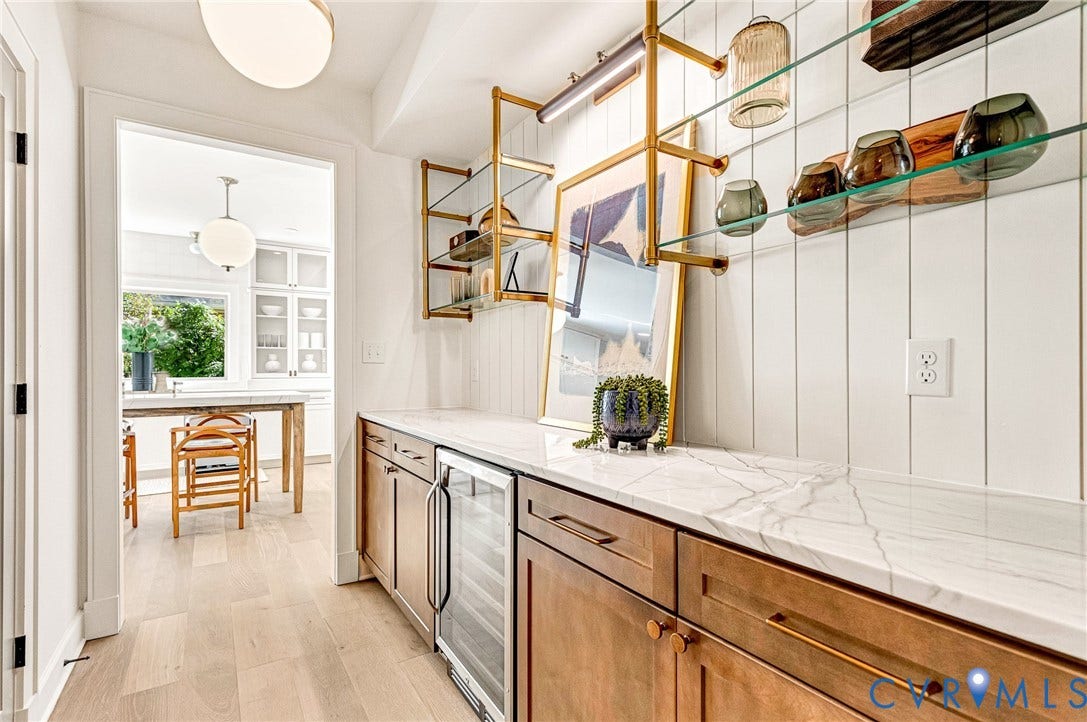 404 Waveny Road, Westham, Henrico, VA 23229 Custom cabinetry featuring integrated wine refrigerator, stone-patterned countertops, vertical shiplap wall paneling, and metallic open-frame shelving with glass surfaces