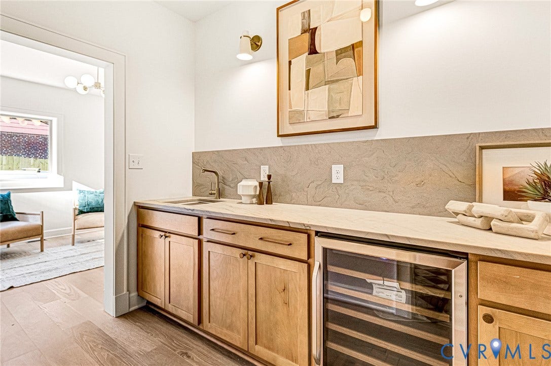 404 Waveny Road, Westham, Henrico, VA 23229 Custom cabinetry with wood finish, stone-surface countertop, integrated beverage refrigerator, stone backsplash, and wall-mounted metal light fixtures
