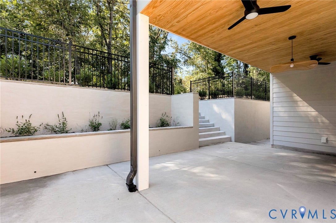 404 Waveny Road, Westham, Henrico, VA 23229 Covered patio with a wood-finished ceiling, integrated ceiling fans, concrete flooring, tiered retaining walls with metal fencing, and exterior stairs