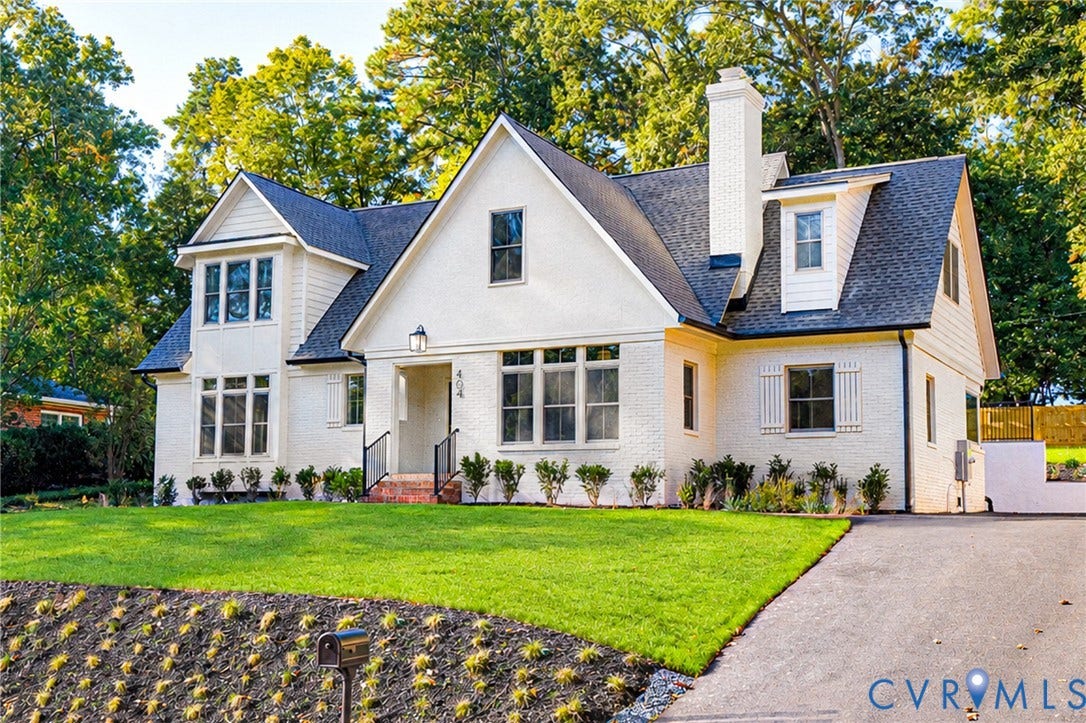 404 Waveny Road, Westham, Henrico, VA 23229 Traditional brick exterior featuring a steep-pitched roofline, multi-pane windows, a central chimney, and an asphalt driveway