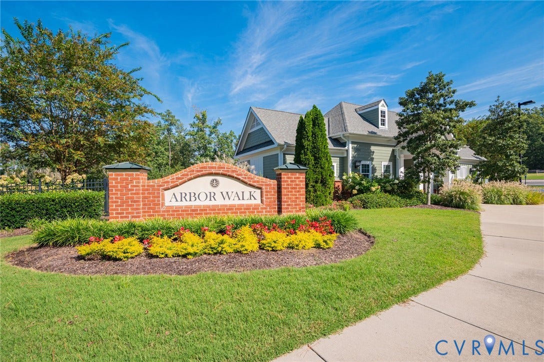 7101 Desert Candle Drive, Moseley, VA 23120 Brick entrance monument with "ARBOR WALK" inscription, surrounded by manicured landscaping, a paved walkway, and lush green lawn
