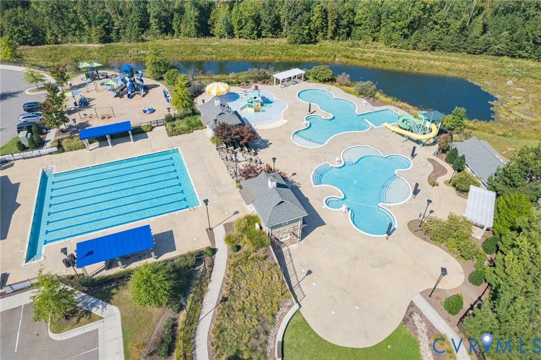 7101 Desert Candle Drive, Moseley, VA 23120 Community amenities featuring a lap pool, multiple freeform pools, water slide, and playground area with shaded structures