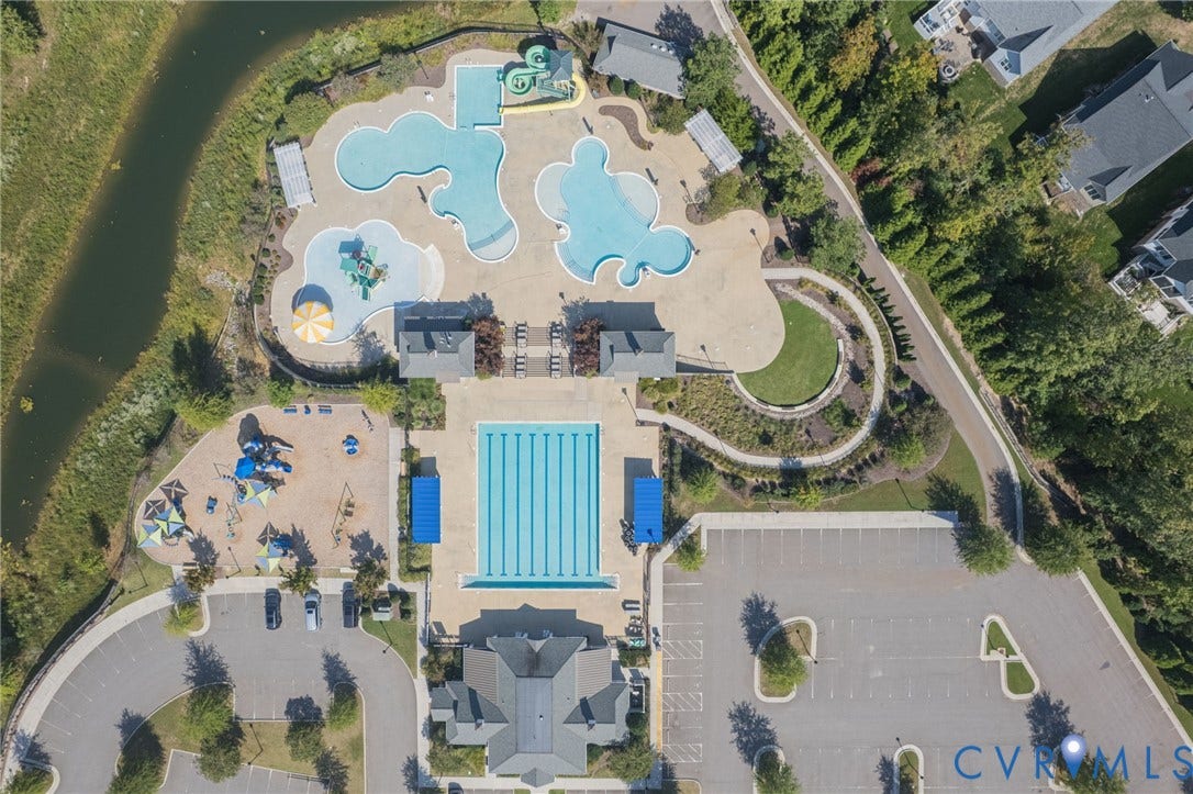 7101 Desert Candle Drive, Moseley, VA 23120 Expansive aquatic complex with multiple swimming pools, dedicated lap pool, water slides, children's play area, and adjacent parking facilities