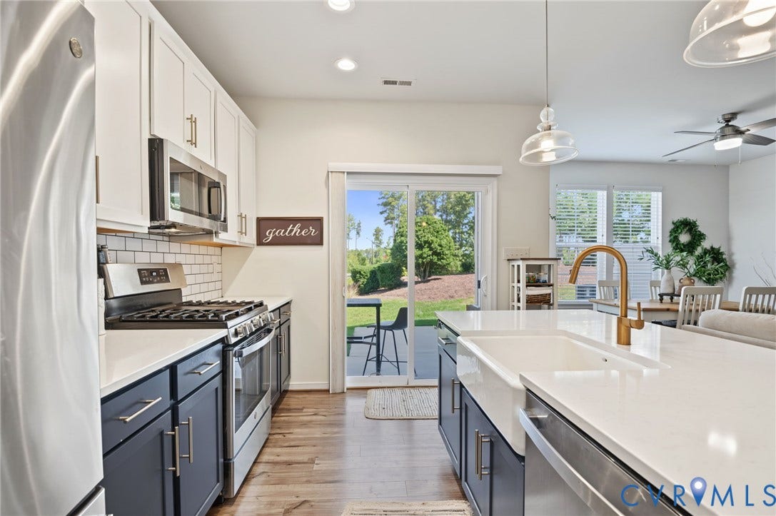 7101 Desert Candle Drive, Moseley, VA 23120 Kitchen featuring stainless steel appliances, white subway tile backsplash, white quartz countertops, a large island with a farmhouse sink, and LVP flooring