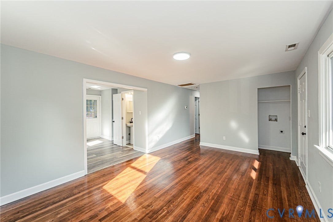 Hardwood flooring, light gray wall paint, white trim, recessed ceiling light, and an open closet space