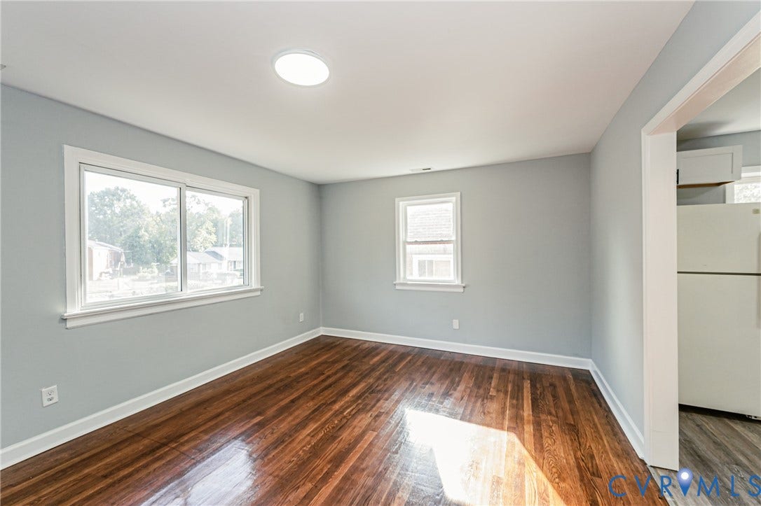 Hardwood flooring, painted walls, white trim, recessed lighting, and a window