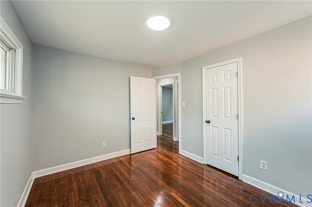 Hardwood flooring, light gray walls, white trim, recessed ceiling light, and a window with white casing