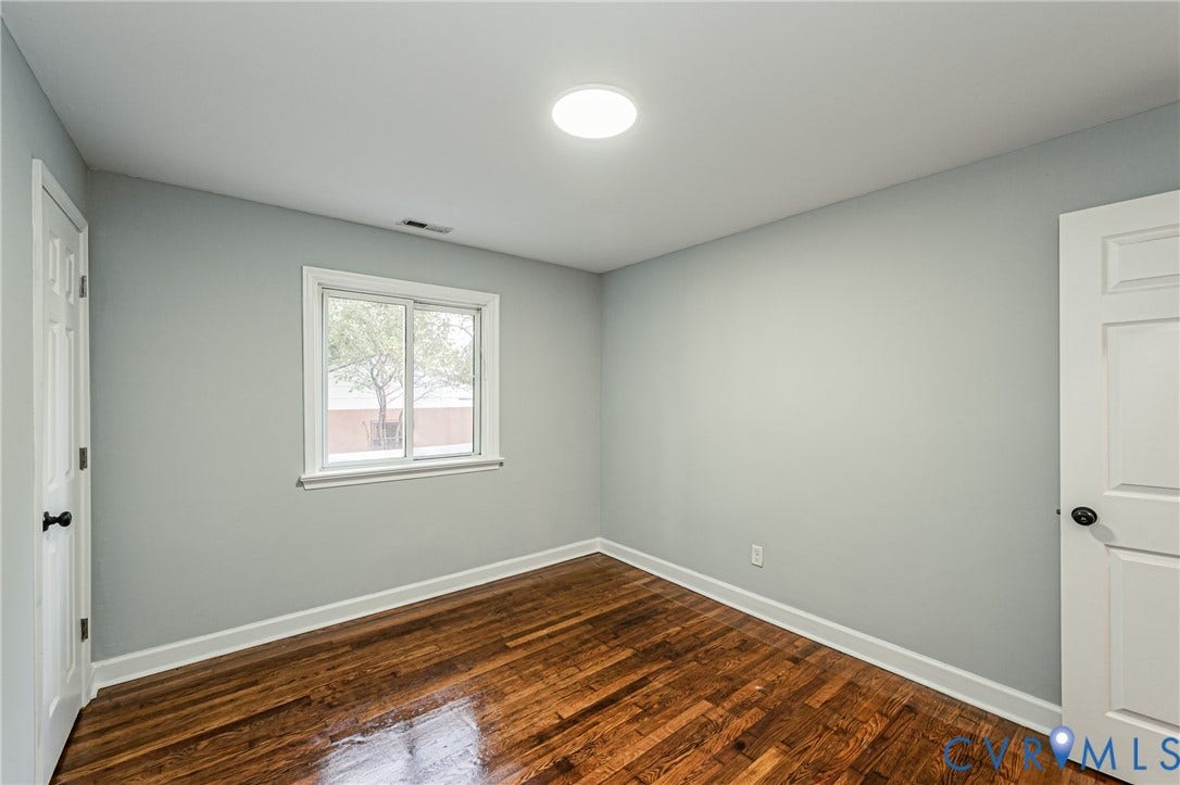 Hardwood flooring, recessed lighting, double-pane window, white trim, and a paneled door