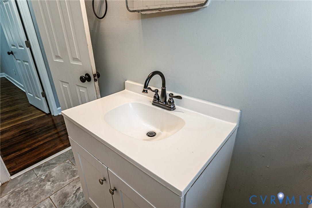 White vanity with integrated sink, oil-rubbed bronze faucet, and gray wall paint