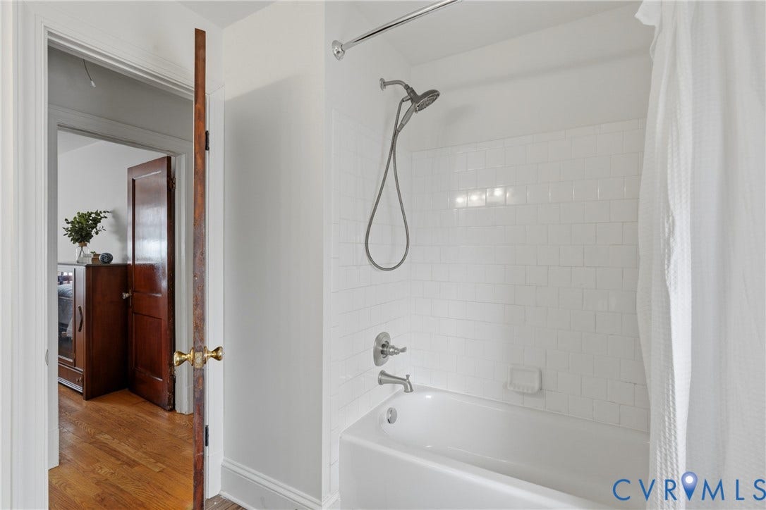 White subway tile shower surround with a built-in tub and chrome fixtures