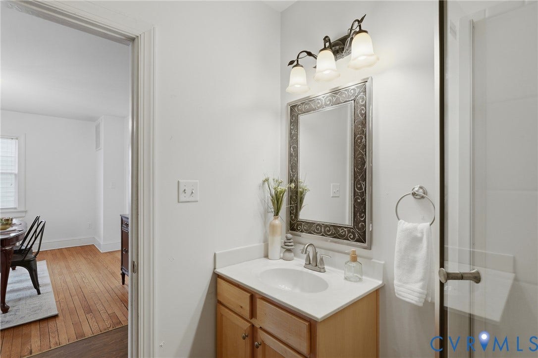 Single vanity with a white countertop and a drop-in sink