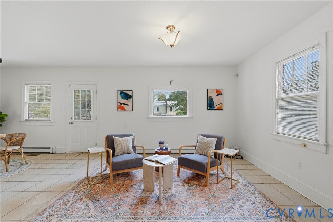 White walls, tiled flooring, multiple windows, and a glass-paneled door