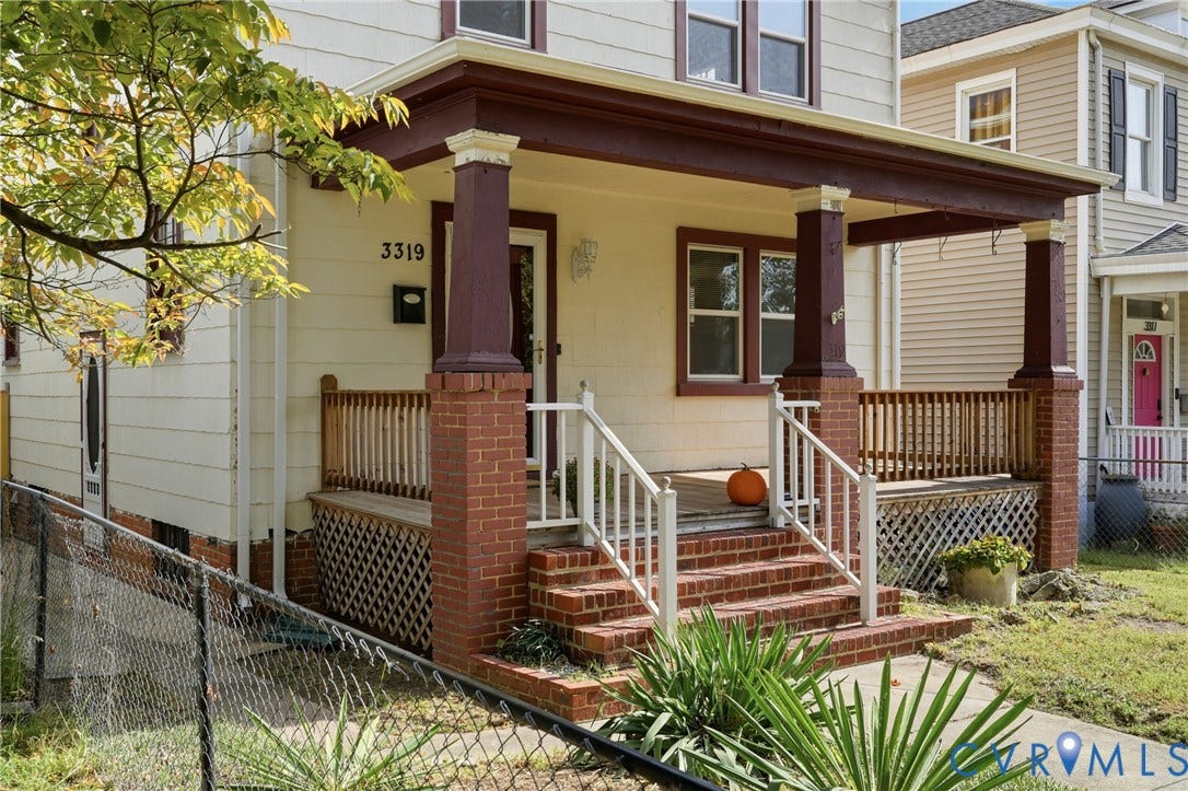 Front porch featuring brick columns, wood railing, and brick stairs