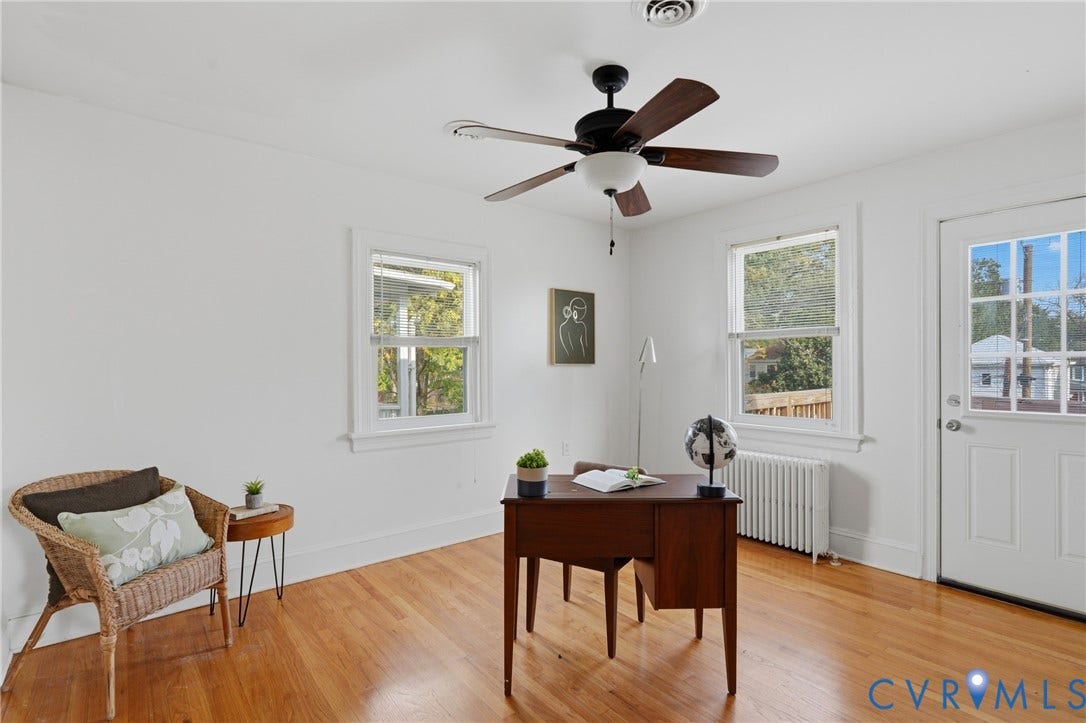 Hardwood flooring, white walls, two windows, and a ceiling fan with light fixture