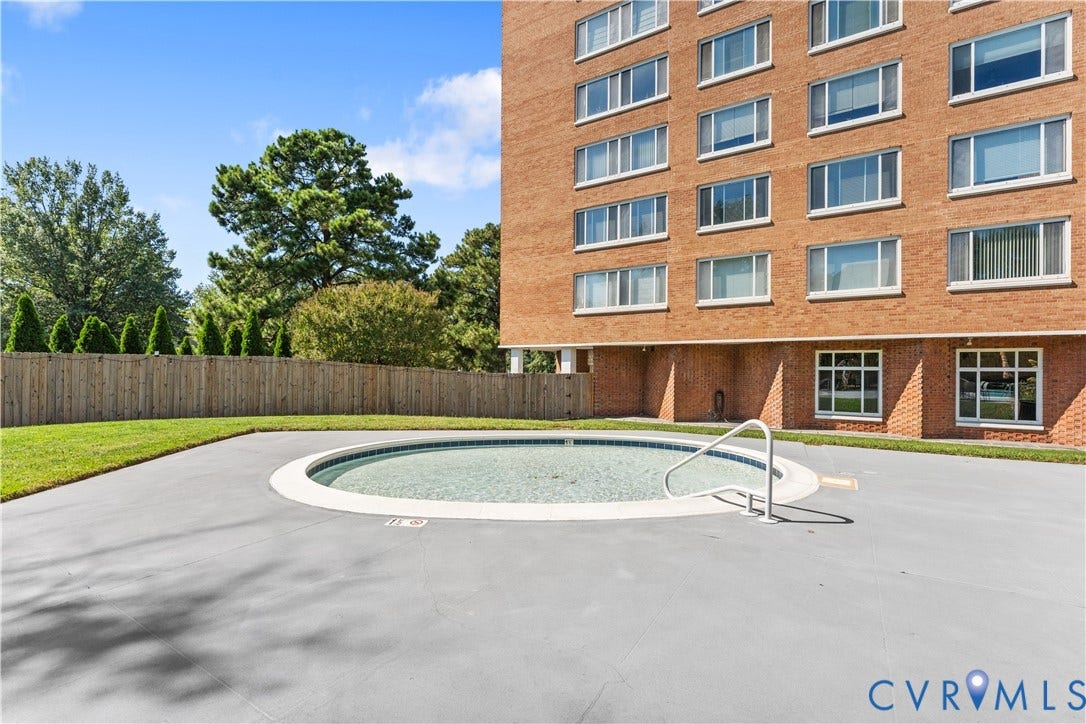 In-ground pool featuring a tiled interior, perimeter coping, and a handrail