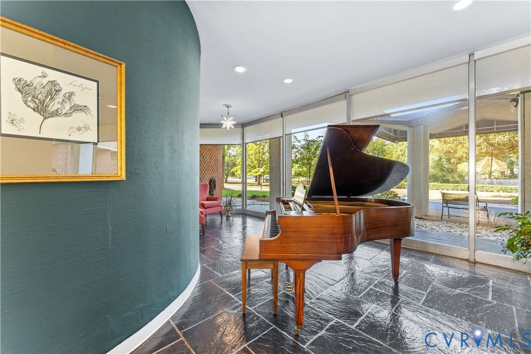 Curved accent wall, slate tile flooring, floor-to-ceiling windows, recessed lighting, and a starburst flush mount light fixture