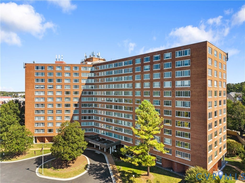 Brick facade with multiple levels, featuring numerous windows