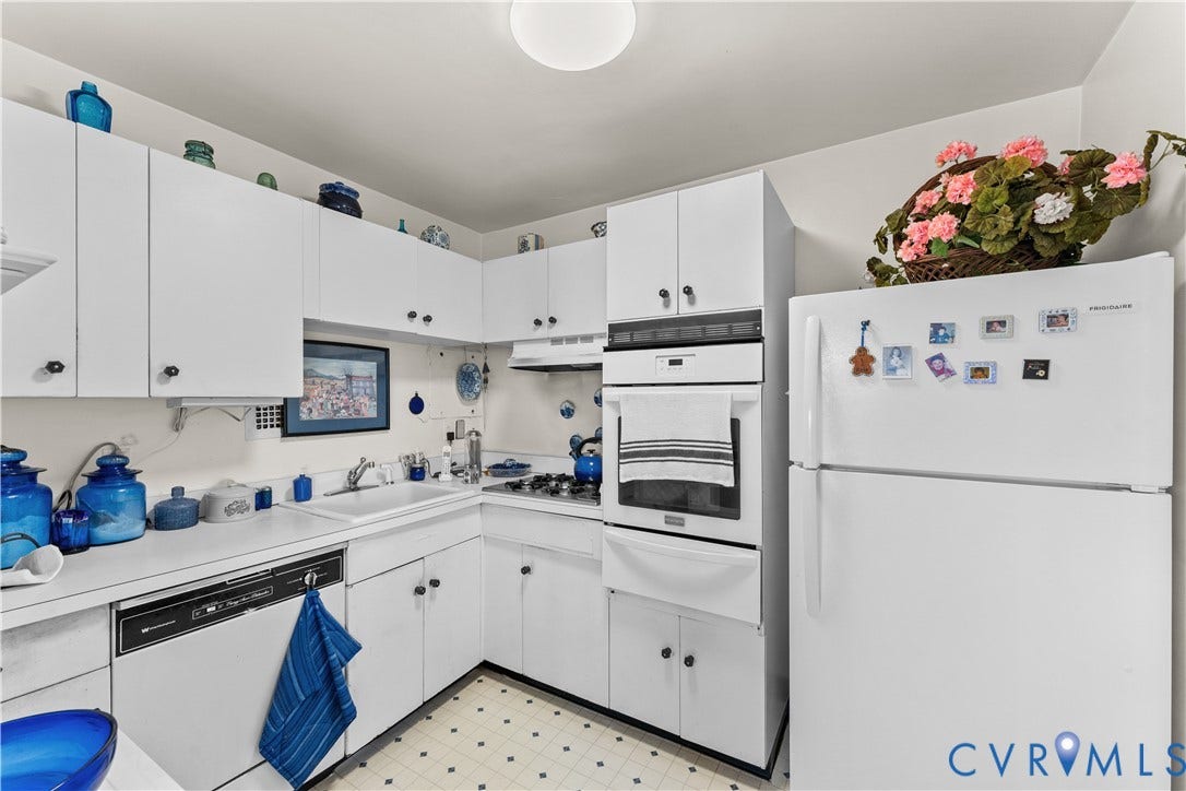 Kitchen featuring white cabinetry, white appliances, built-in oven, and a patterned floor