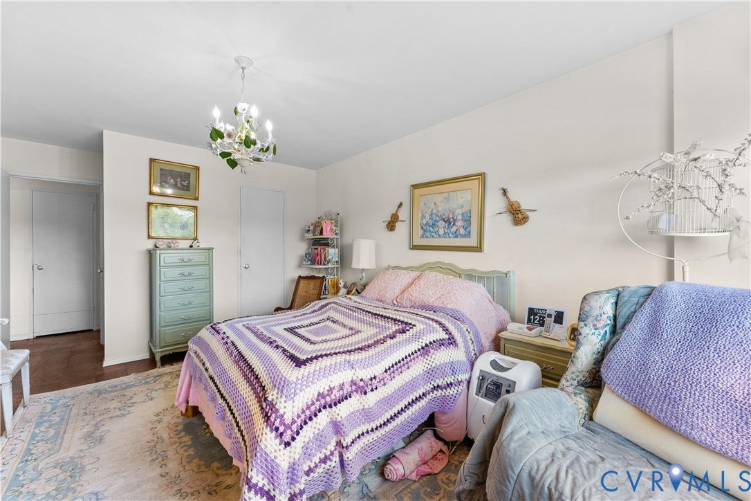 Recessed doors, wood-finish flooring, and a chandelier with floral accents