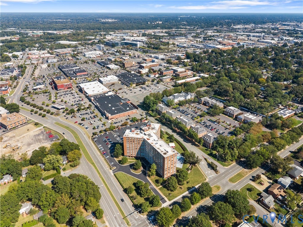 Aerial perspective showcasing urban development, commercial properties, residential buildings, and tree-lined streets