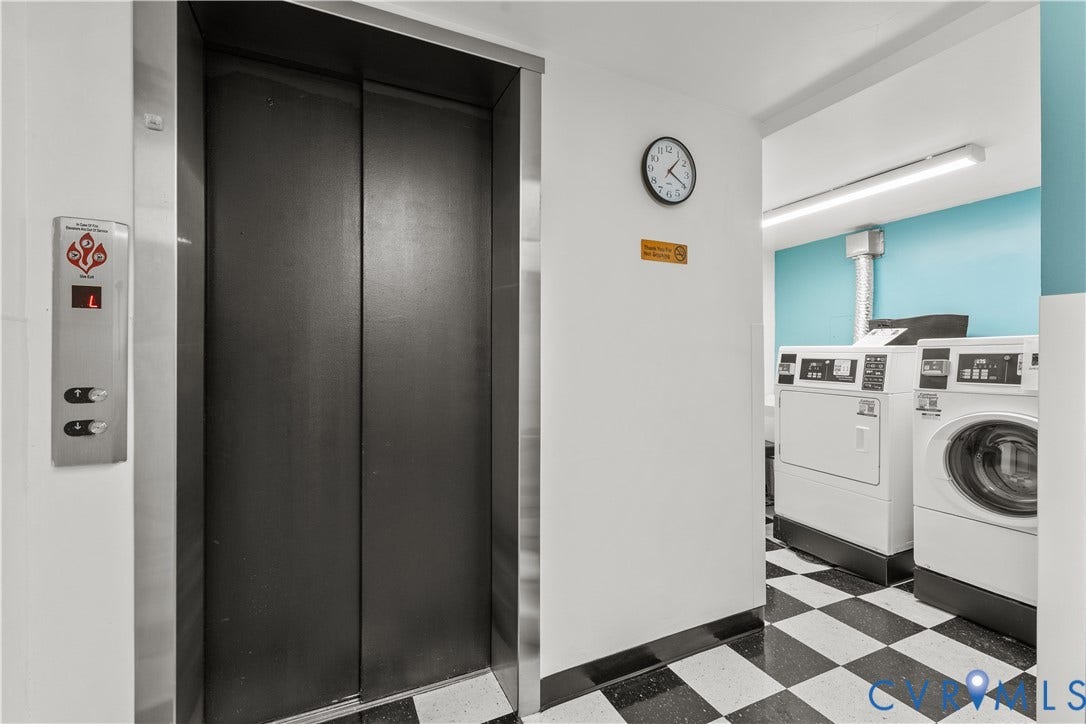 Elevator access, laundry facilities with multiple machines, black and white checkered flooring, and light blue wall accents