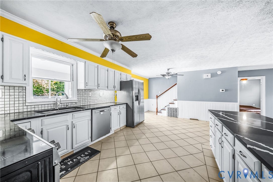 Kitchen featuring white cabinetry, dark countertops, a tile backsplash, stainless steel appliances, and tile flooring